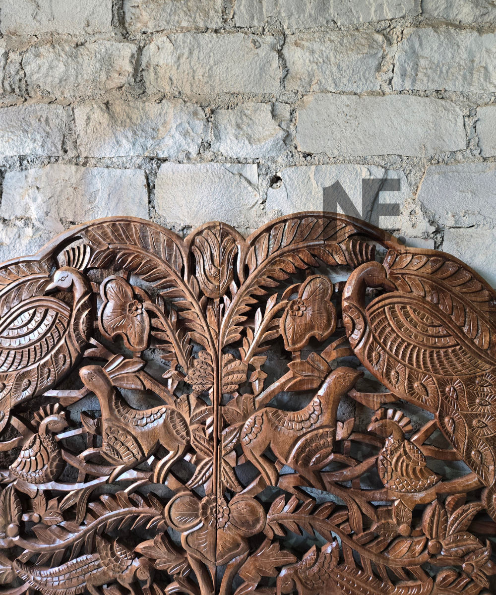Close-up of peacock carving on a wooden headboard