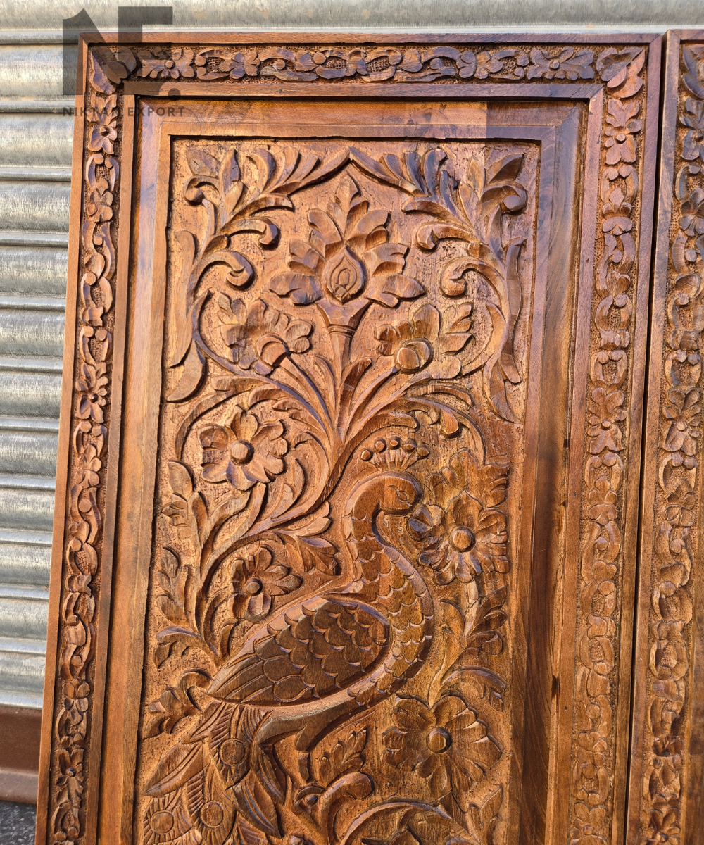 Detailed foliage and vine carving on a wooden panel