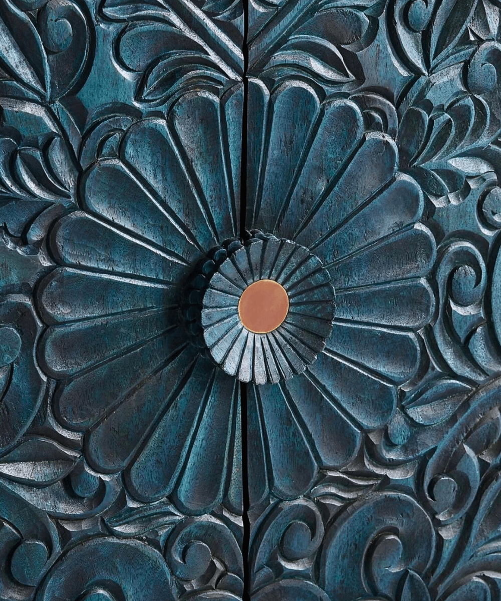 Close-up of hand-carved floral patterns in distressed indigo finish