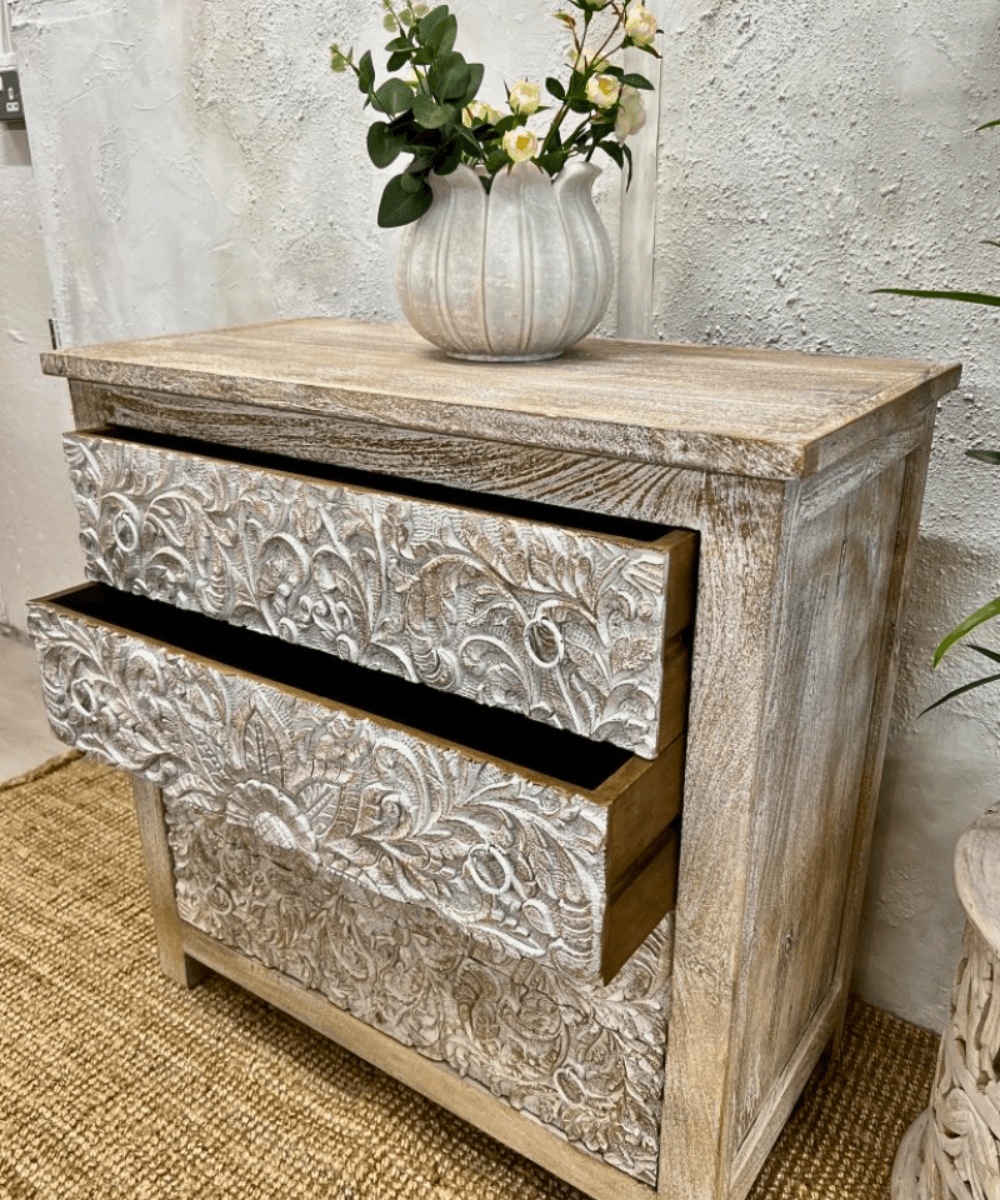 Close-up of intricate hand-carved petal designs on drawers