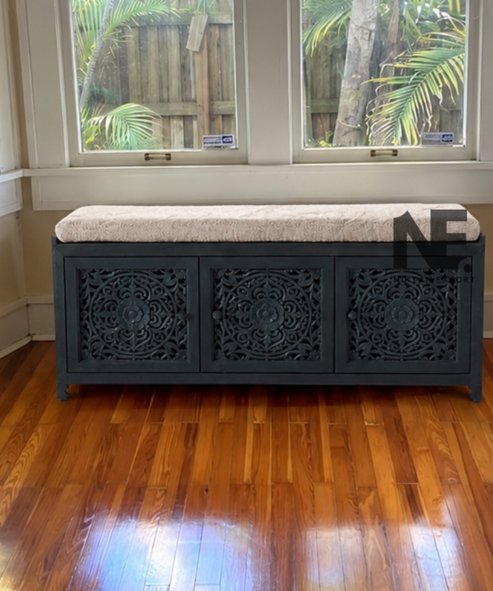 Dark teal carved wooden bench with cream cushion