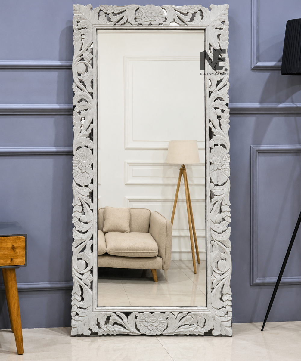 Ornate white carved full-length floor mirror with floral detailing and decorative frame.
