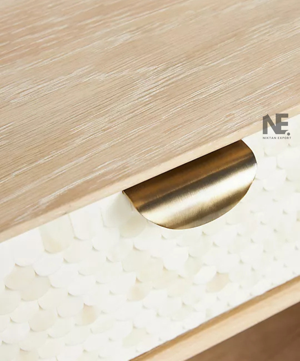 Gold-tone handles on a cream storage cabinet