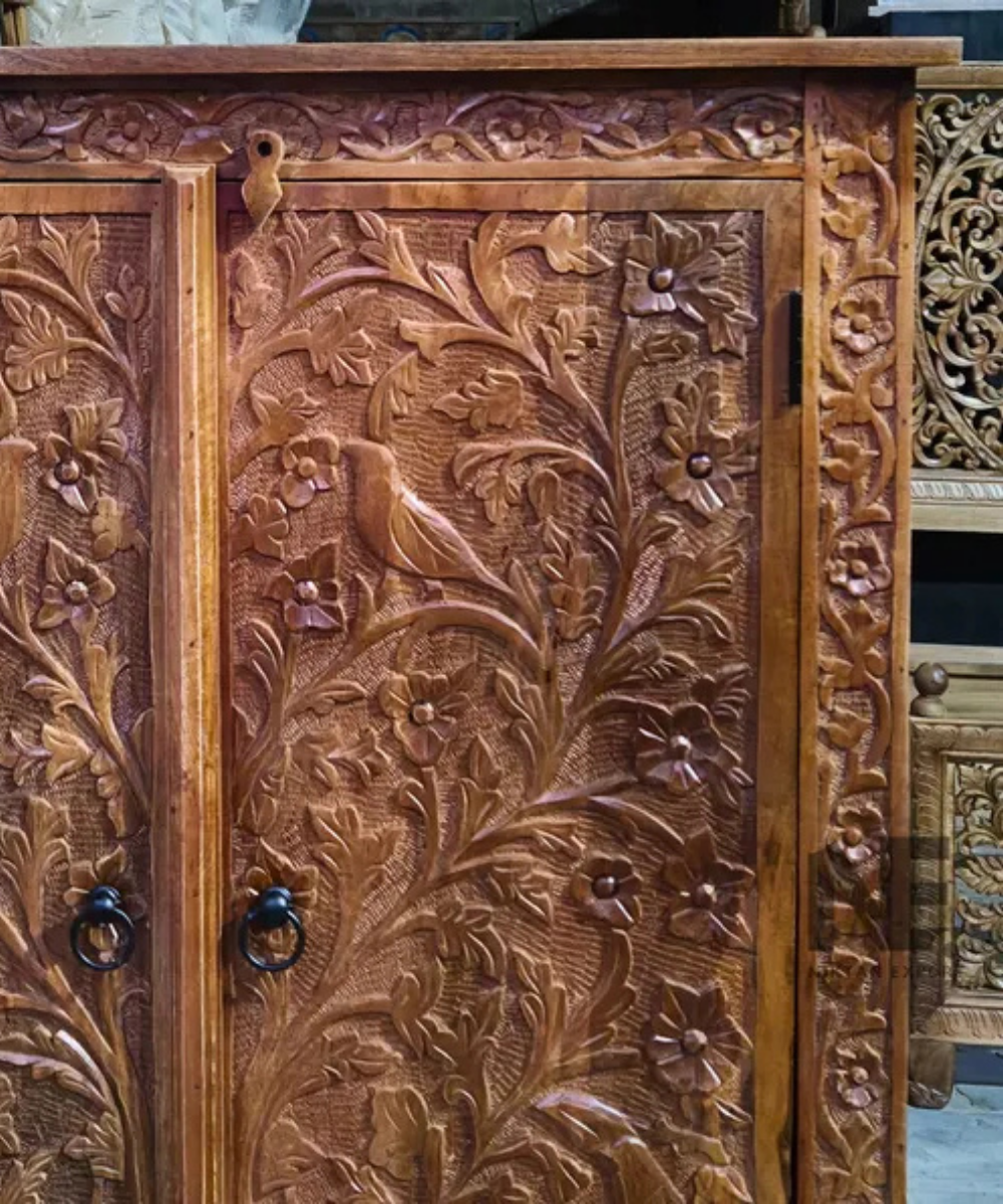 carved wooden armoire with birds and leaves
