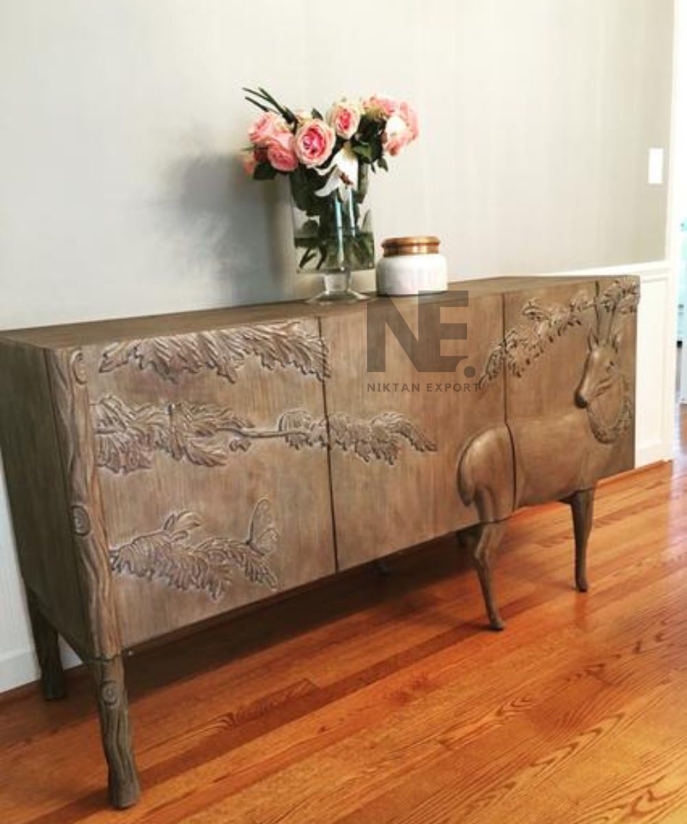 Carved deer and leafy branches on wooden sideboard