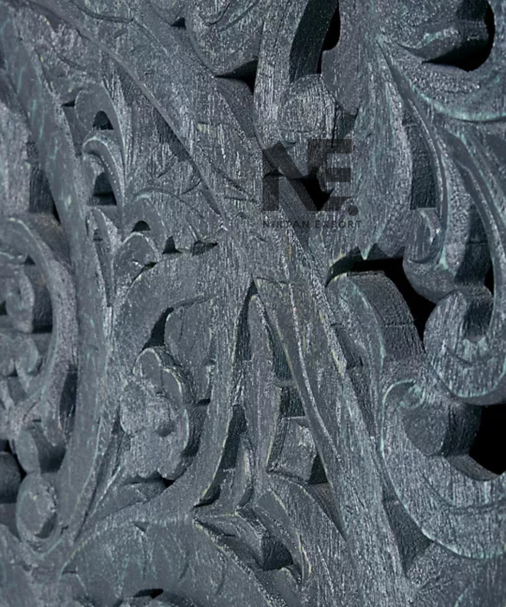 Close-up of floral scrollwork on black carved cabinet