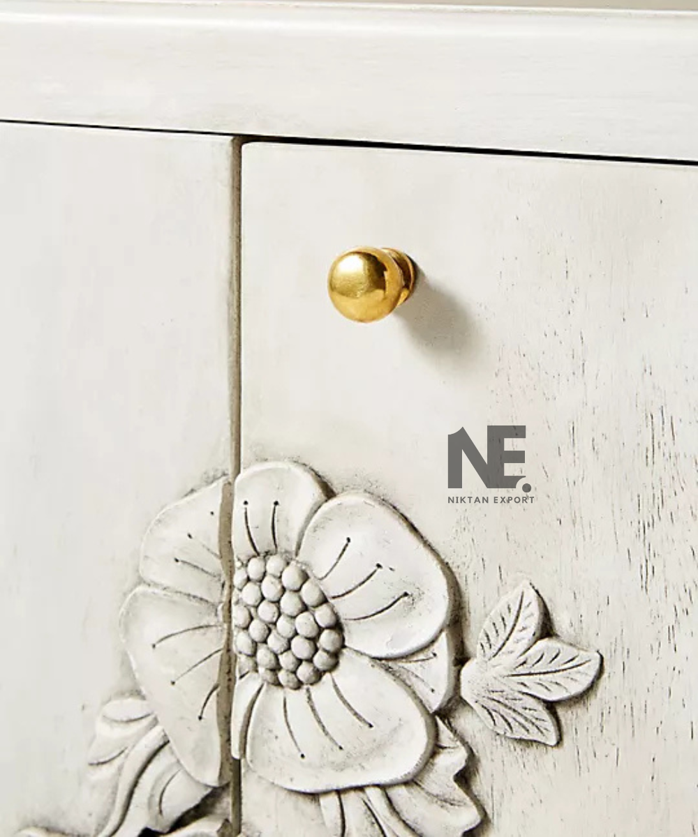 Close-up of raised floral carving on cream sideboard
