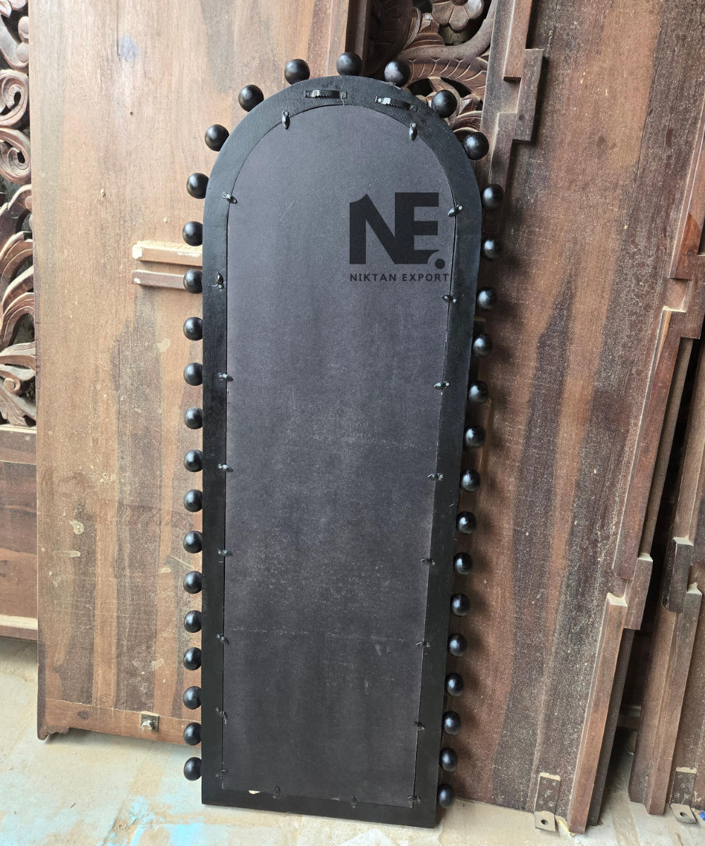 Close-up of rounded black studs on an arched mirror frame