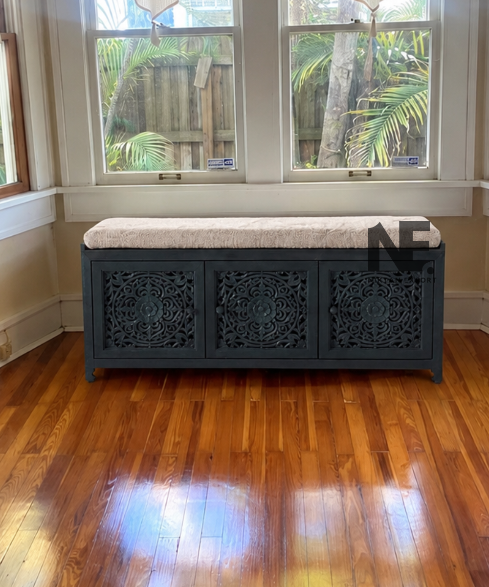 Dark teal carved wooden bench with cream cushion