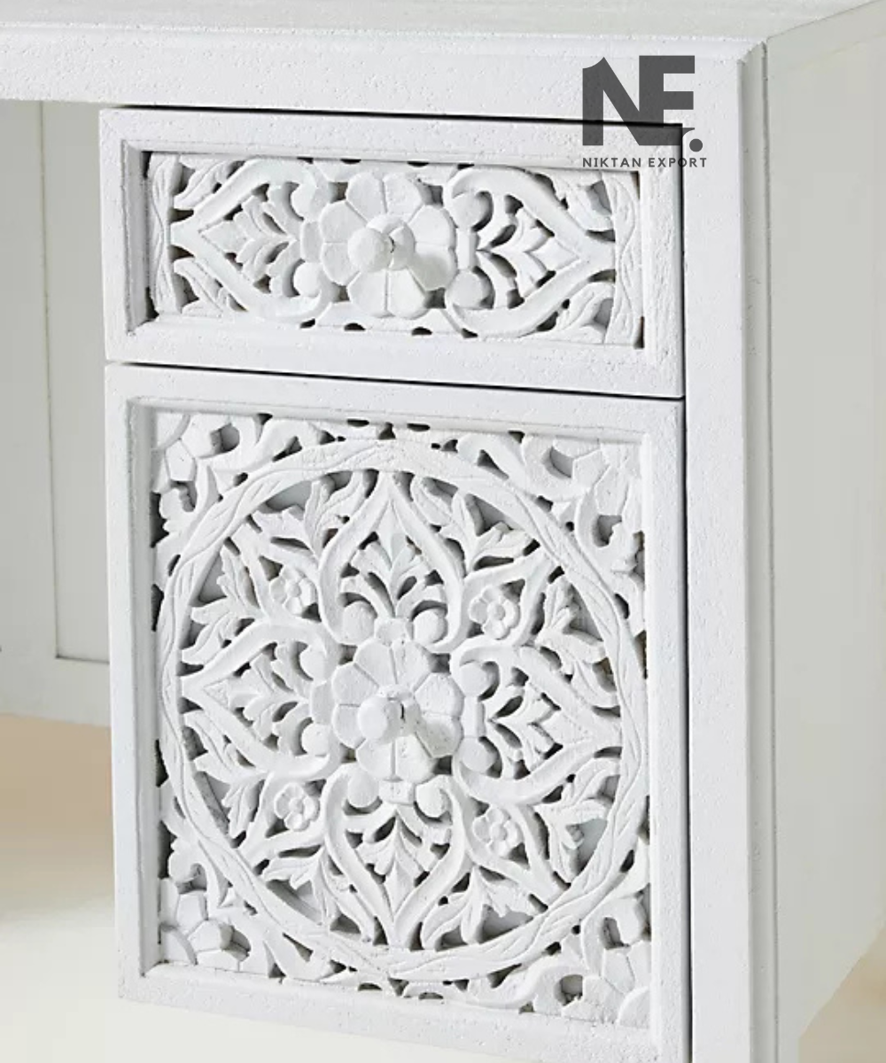 Floral carved drawer fronts on a white wooden desk