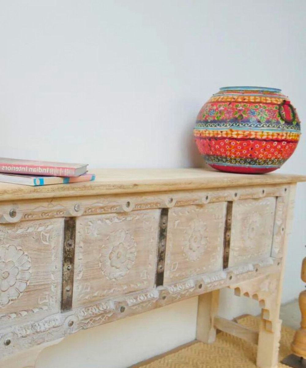 Close-up of intricate floral carvings on console table