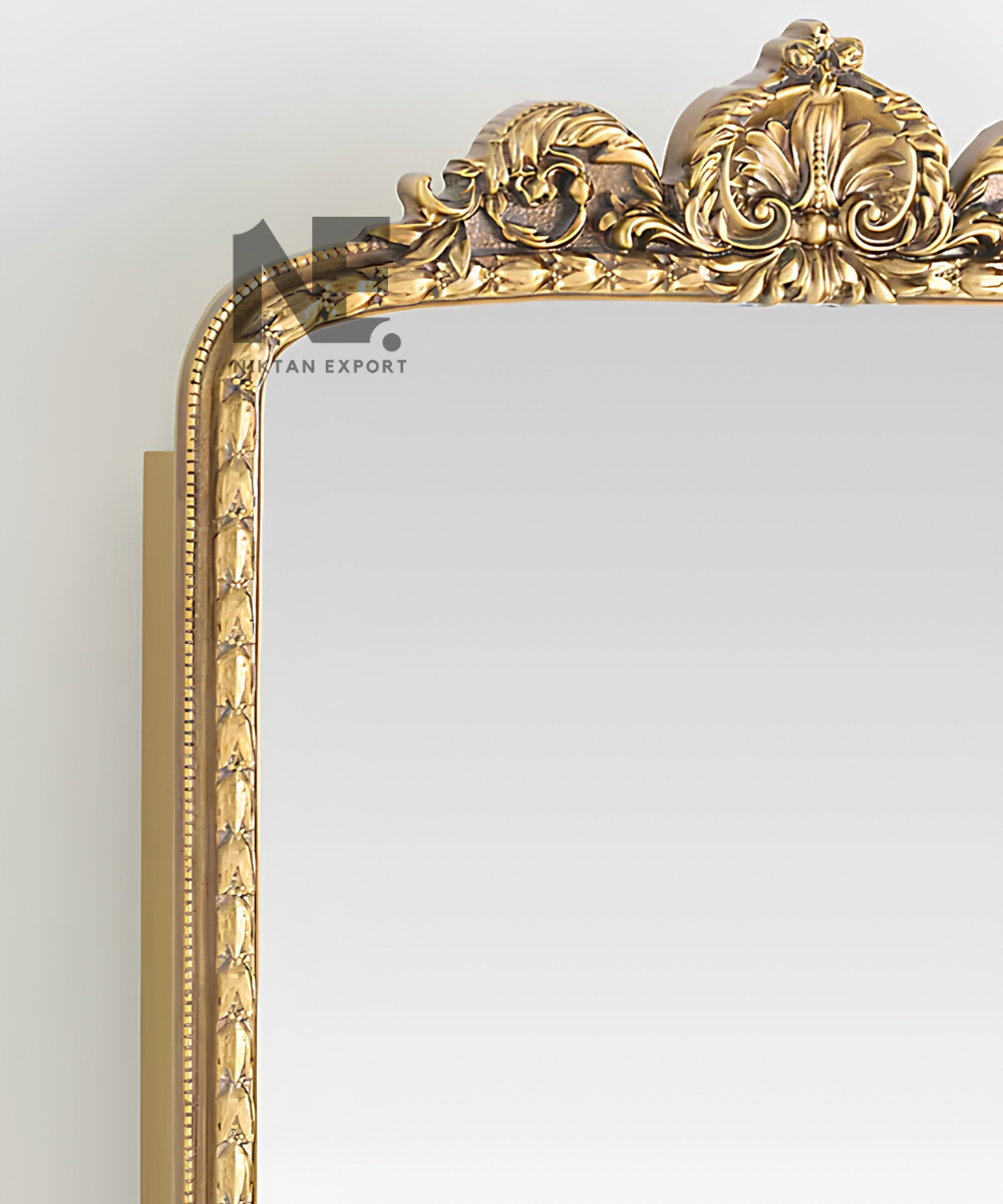 Close-up of ornate detailing on a gold mirror cabinet
